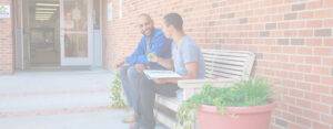 Background image of a student and teacher at Sheridan College in Johnson County