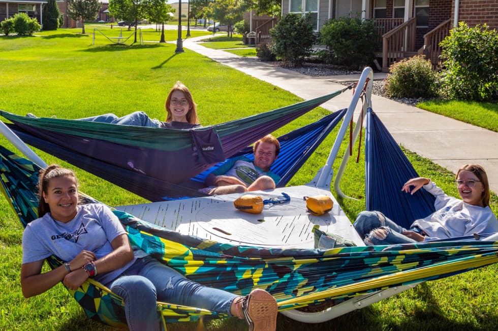 Sheridan College students laying in hammocks on campus