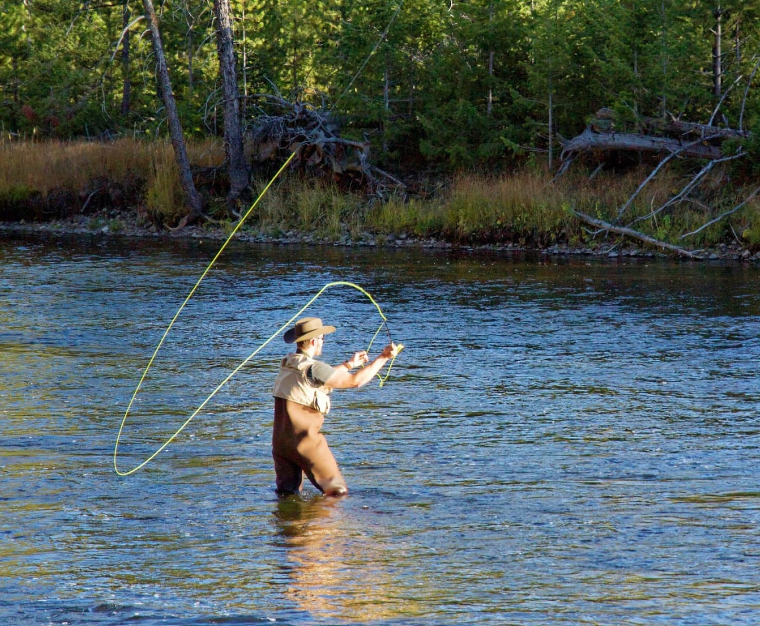 Guy fly fishing in a river.
