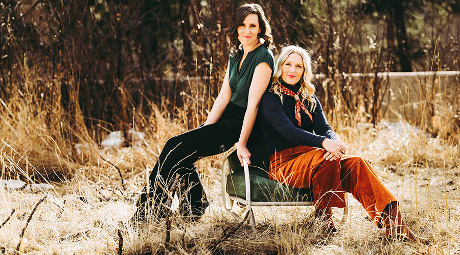 Edie Carey and Sarah Sample photo, outside sitting together on a chair in the grass