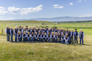 Photo of the rodeo teams out in a field with the Bighorn Mountains in the distance