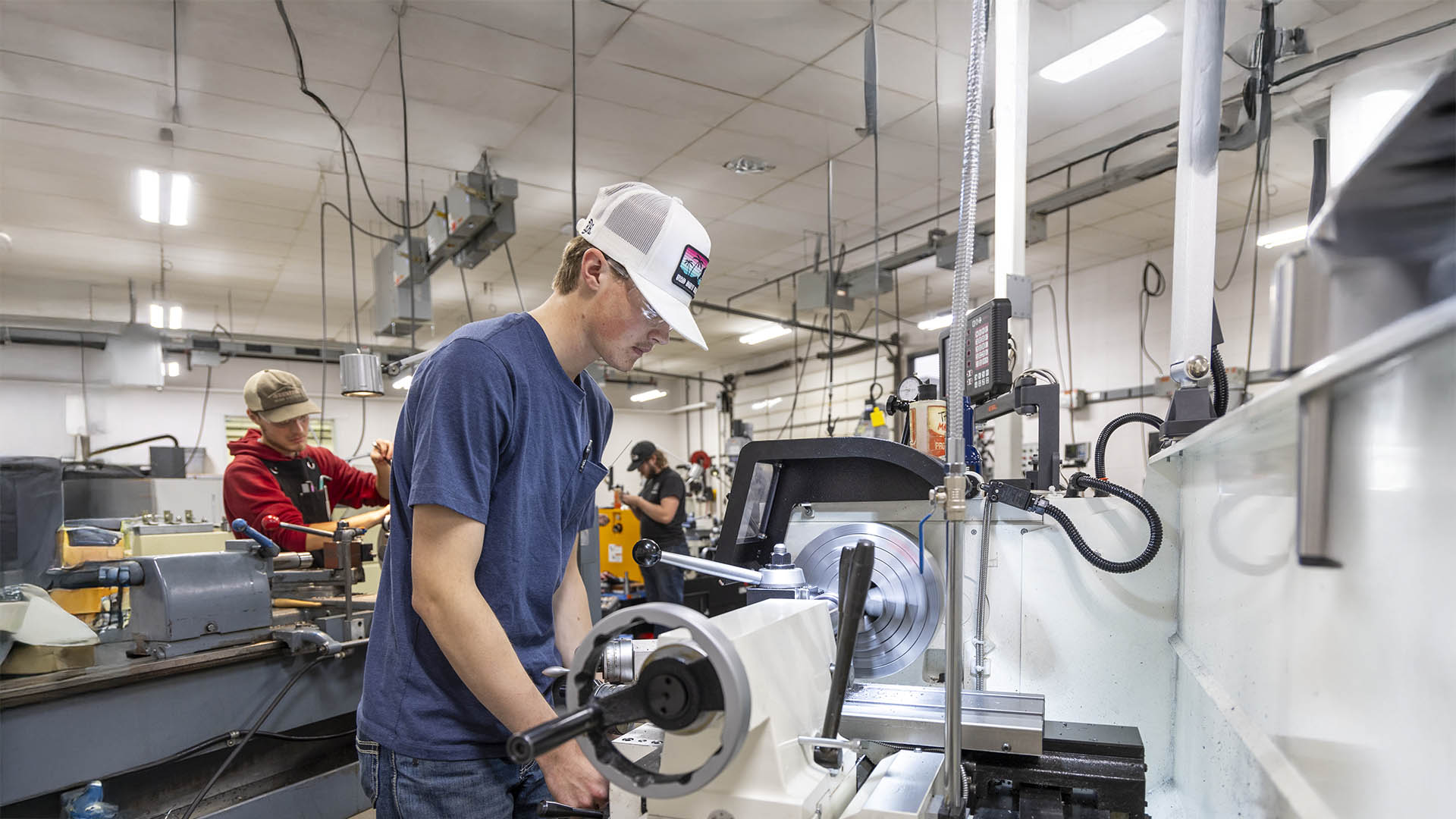 Multiple machining students working in the machine tool shop space