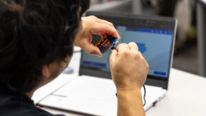 Photo of student at Sheridan College working with computer cable.