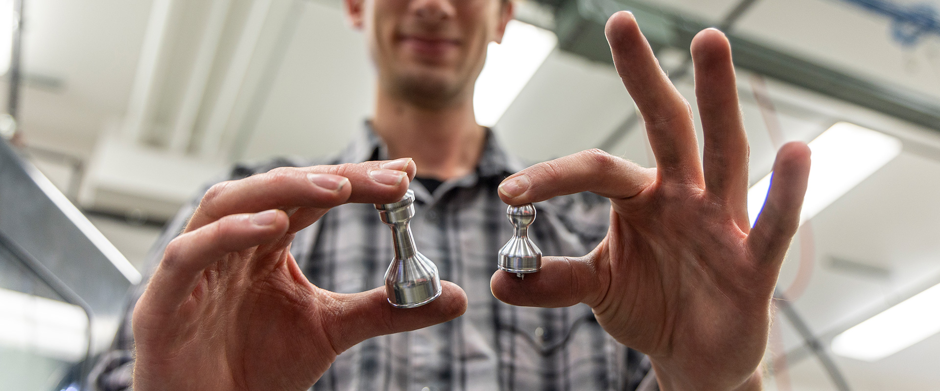 Sheridan College Machine Tool student showing the chess pieces he made.