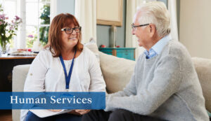 Photo of two older individuals, one clearly in a supportive role offering guidance to the other.