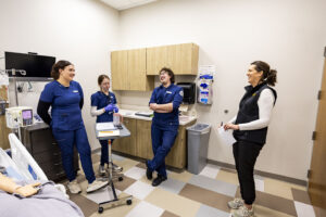 Nursing students and instructor share some laughs as their debrief from their simulation exercise.