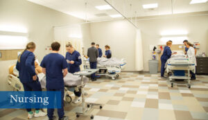 Nursing students in three groups working with manikens during a simulation.