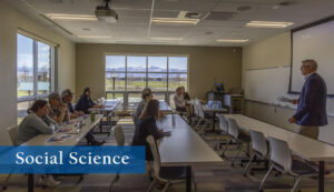 Classroom with students listening to a lecture with the bighorn mountains clearly visible out the window.