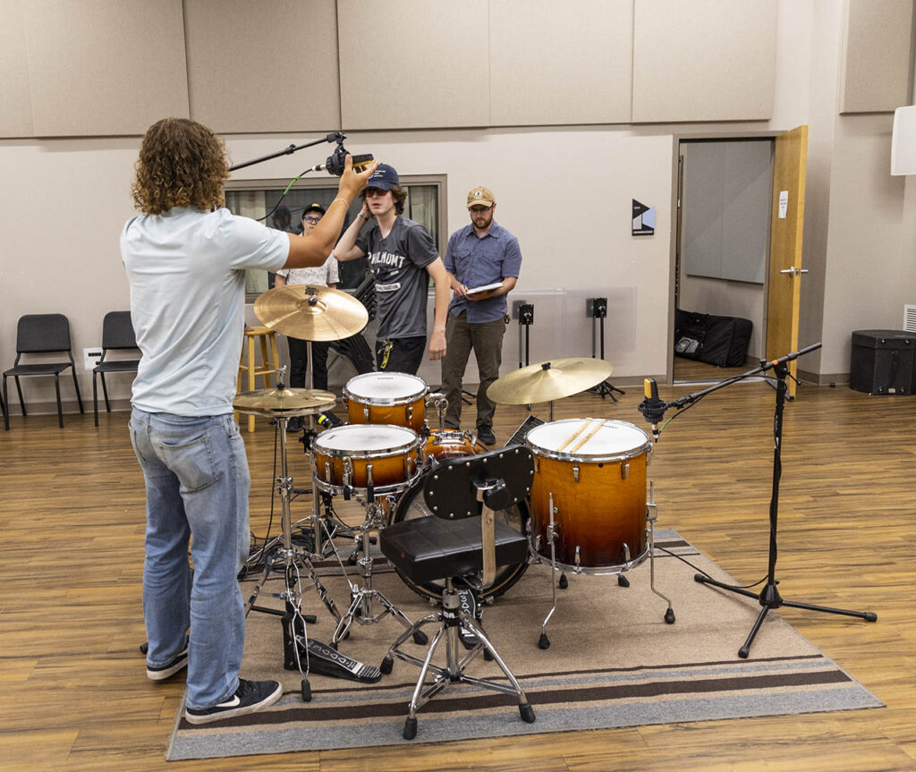 Students setting up to record some drum tracks