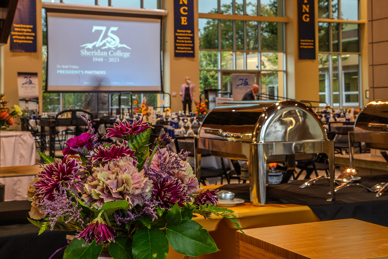 Sheridan College catering photo with bouquet of flowers next to a platter.