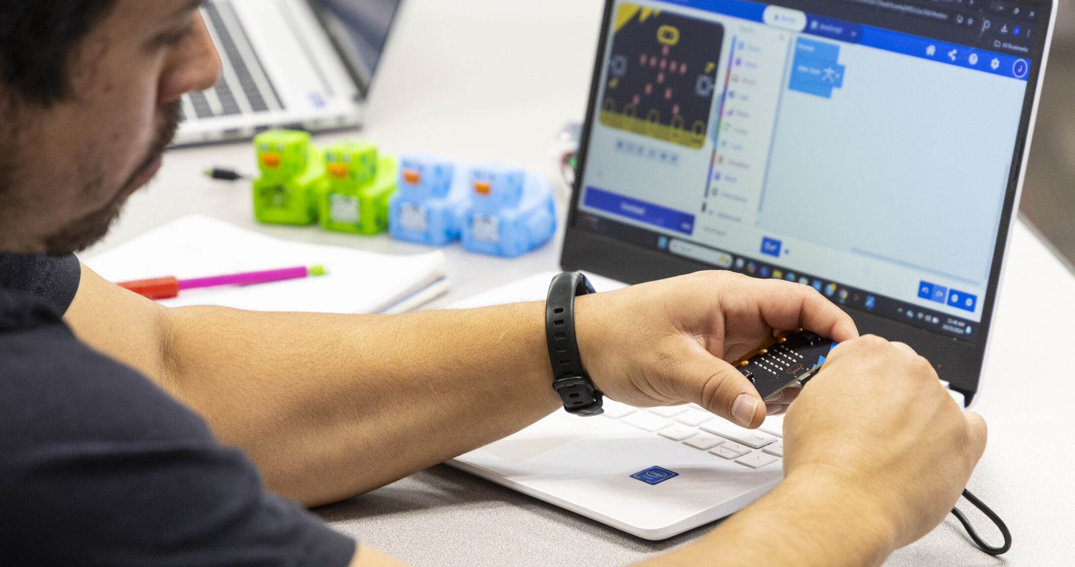 Computing Student working on project with Computing Rubber Duckies next to laptop