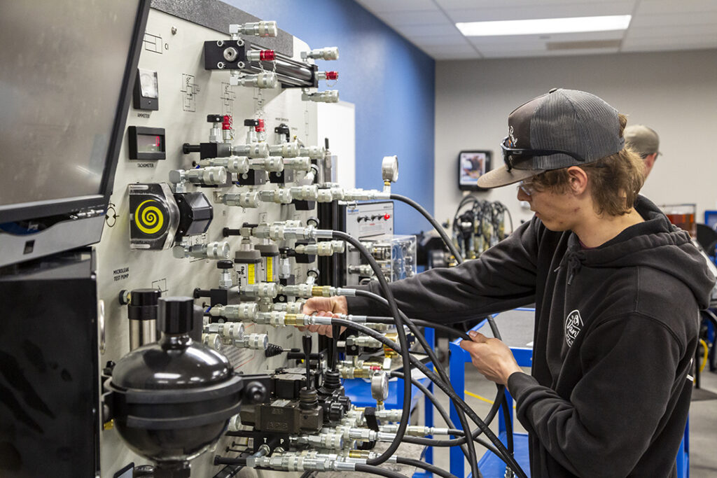 Student using the disel hydraulics lab, lots of hoses