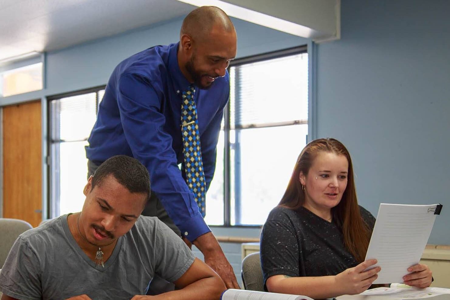 Sheridan College faculty helping a student in the classroom.