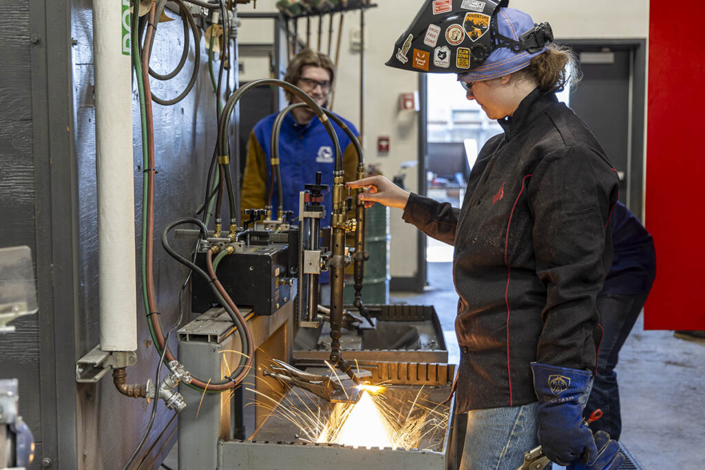 Student using a piece of equipment in the welding lab