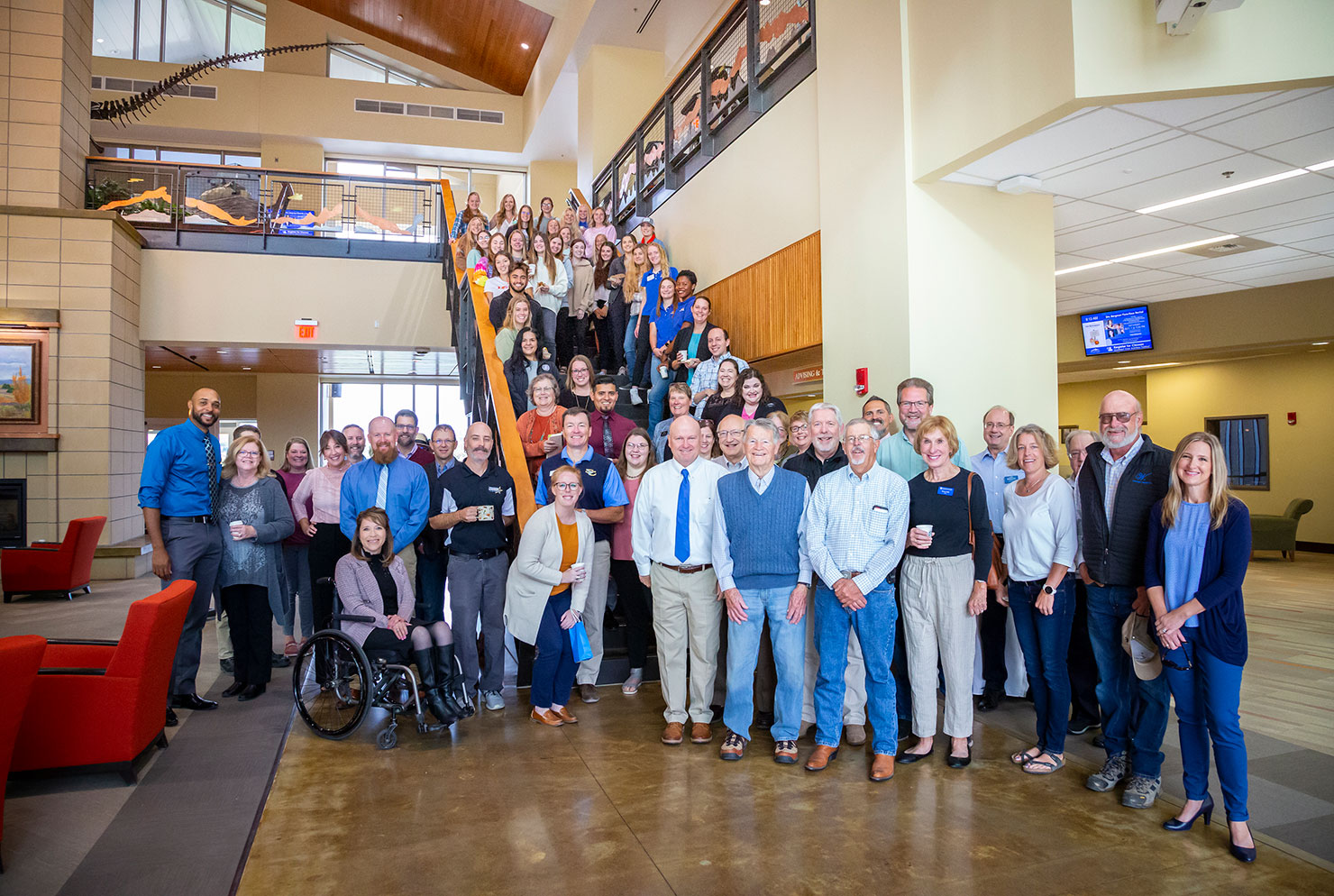 Sheridan College board and staff standing together in the Atrium of the Whitney Academic Center.