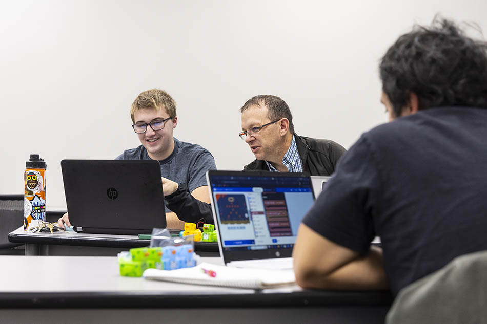 Instructor and student working on laptop computers