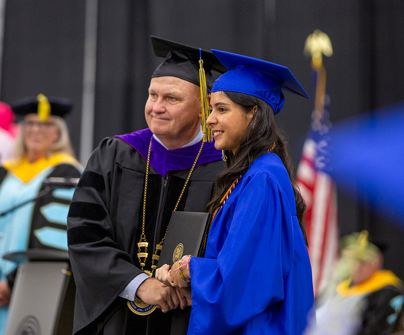 Dr. Walter Tribley and graduate posing for a photo at commencement
