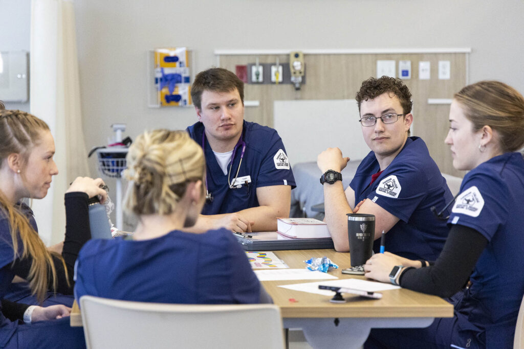 Health Science students at a table discussing a project