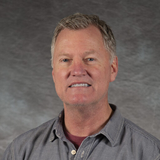 Headshot photo of Russell Rogers against a grey backdrop.