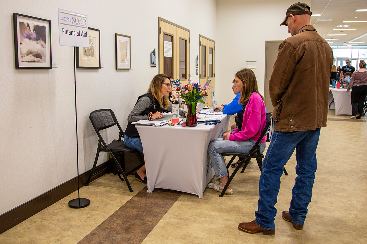 Sheridan College SOAR event photo of student talking with Financial Aid.