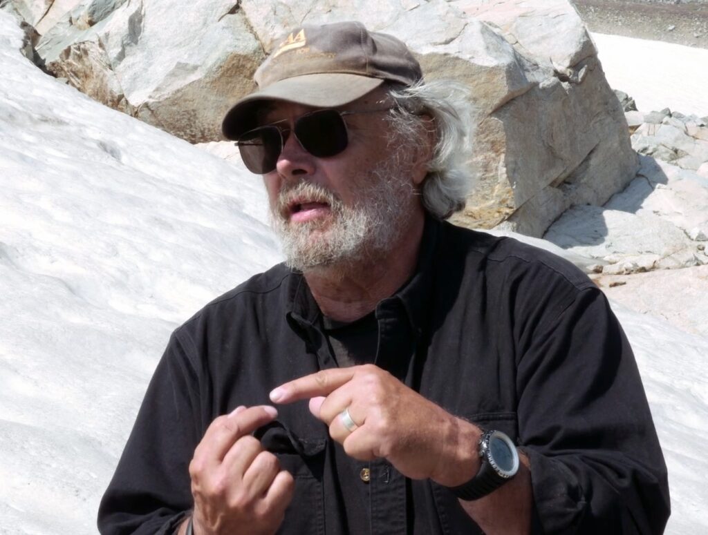 Photo of Larry Todd with a snowfield behind him