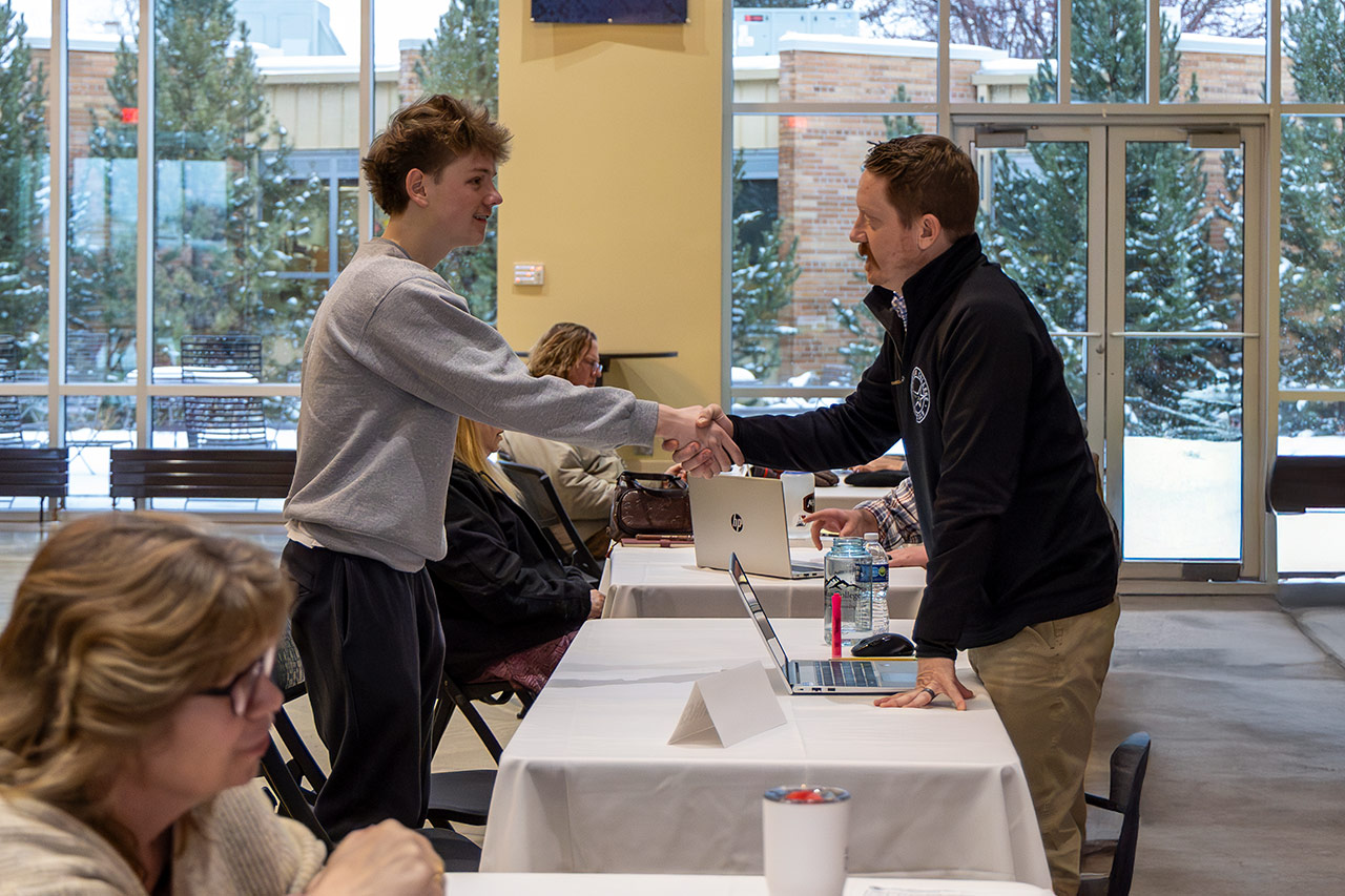 Sheridan College advisor Thad Rigby shakes the hand of a new student at Walk-in Wednesday event.