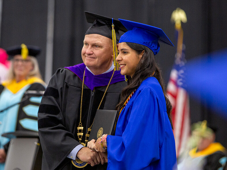 Dr. Walter Tribley and graduate posing for a photo at commencement