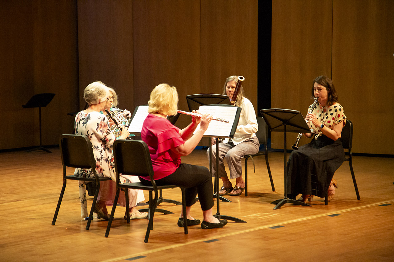 four performers with a variety of wind instruments on stage