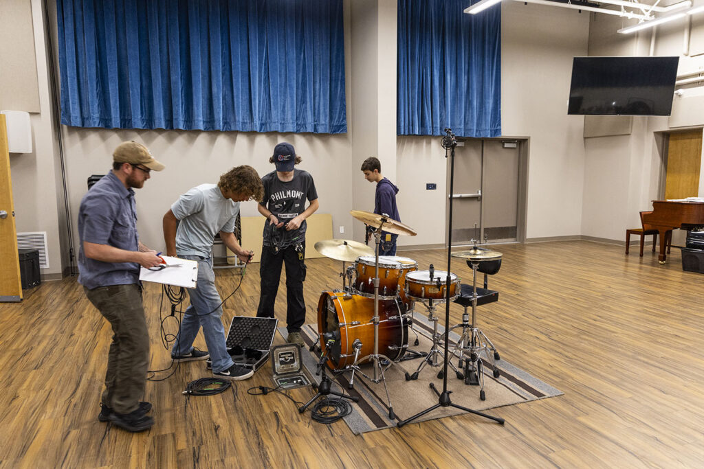 Students setting up to record a drum set