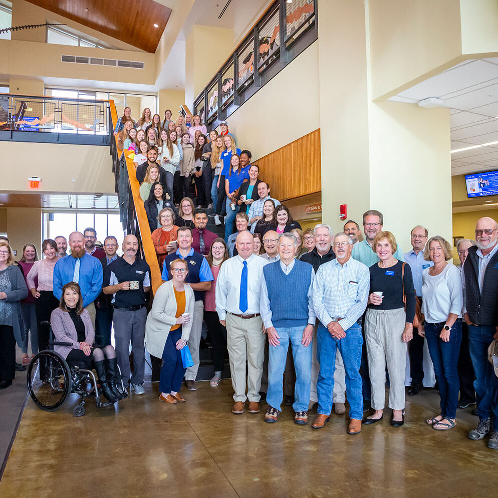 Sheridan College board and staff standing together in the Atrium of the Whitney Academic Center.