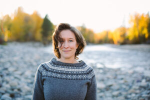 Photo of Sara E. Berns outside with a river flowing behind her.