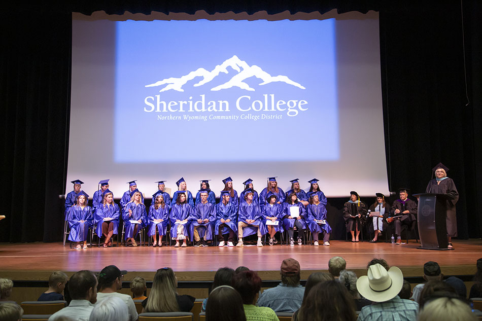 HiSET Adult Basic Education graduates sitting on stage in Kinnison Hall