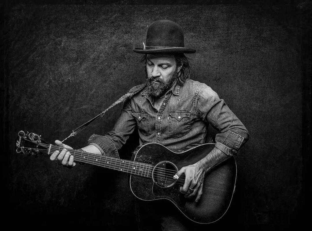 black and white photo of Jalan Crossland playing his guitar