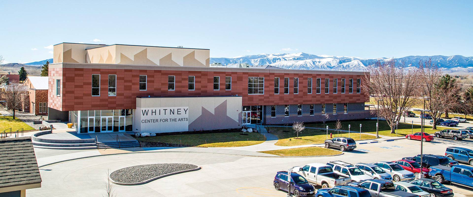 Whitney Center for the Arts building with snowy mountains in the background